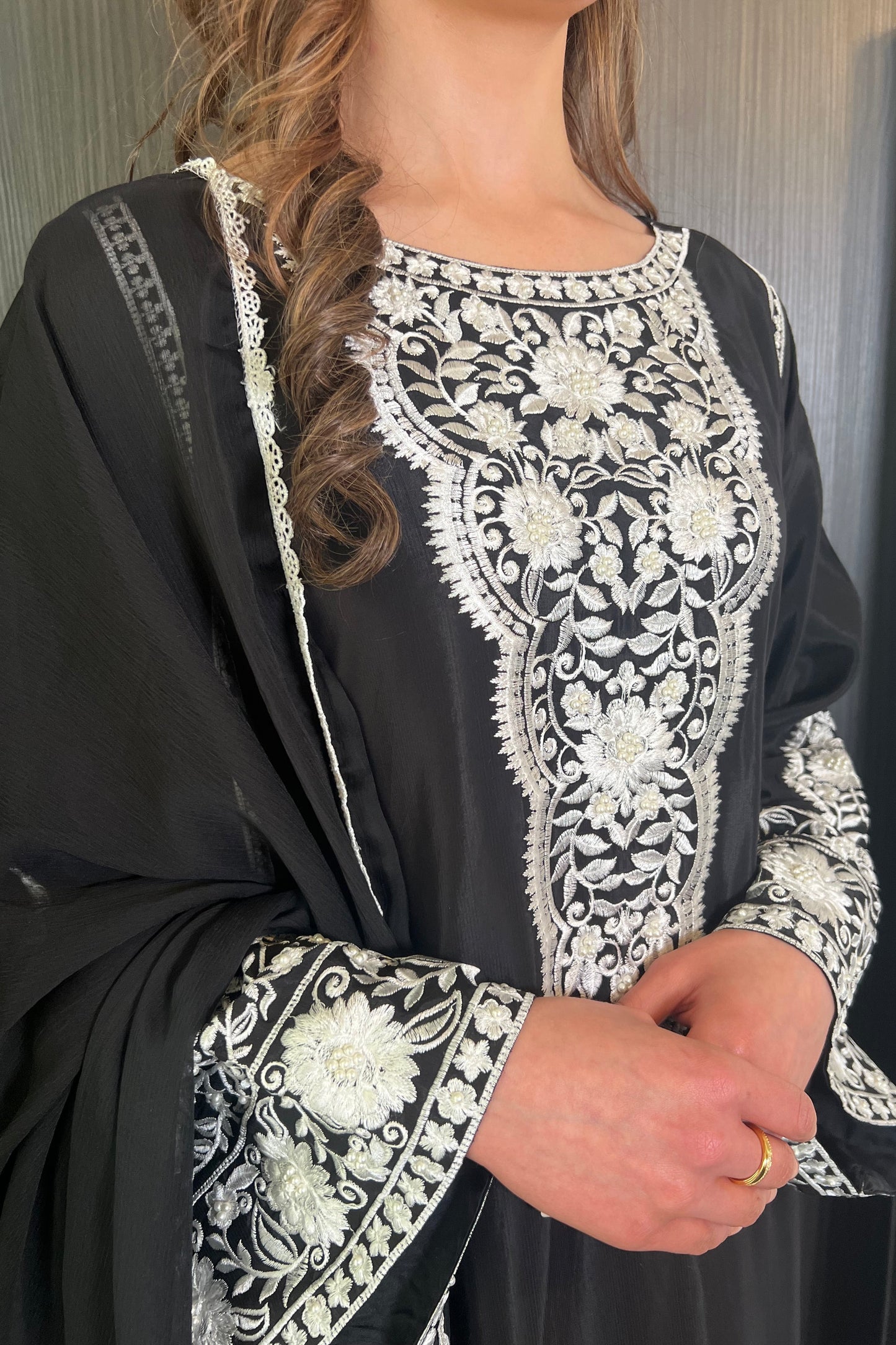 woman wearing pakistani clothing a black shalwar kaftan long kameez with embroidery and pearl details